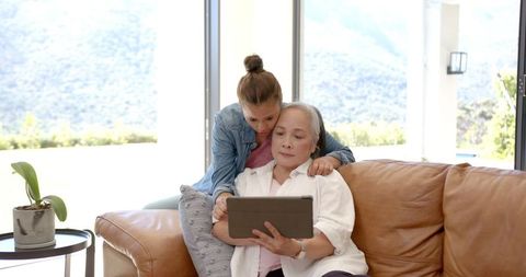 Grandmother and Granddaughter Bonding Over Tablet Technology