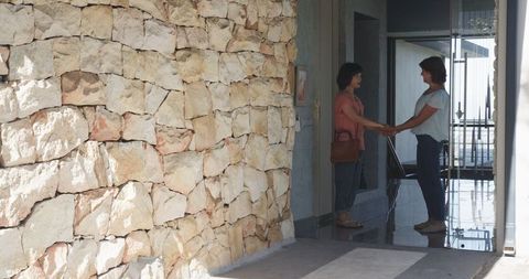 Cheerful Senior Women Hugging and Smiling at Entrance