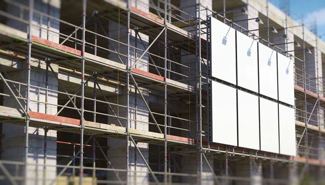 Urban construction scaffolding featuring blank white advertising panels on building facade