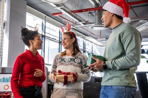 Diverse Coworkers Exchanging Gifts and Smiling During Modern Office Holiday Celebration