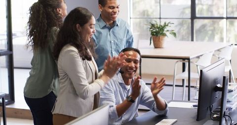 Diverse Colleagues Celebrating Successful Teamwork in Modern Office