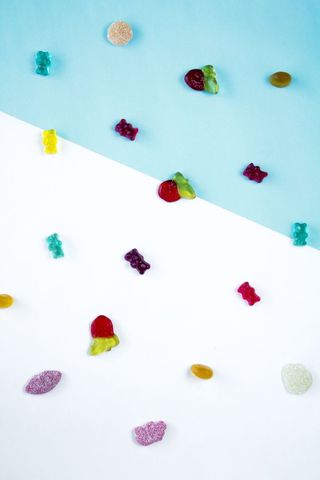 Colorful assorted sweet gummy bear on blue and white background