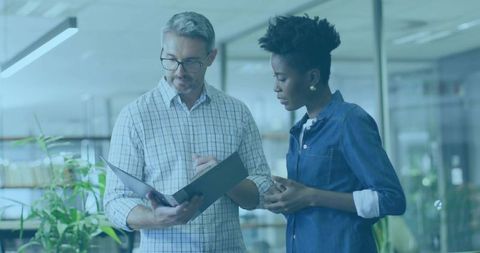 Coworkers Analyzing Documents in Modern Corporate Office