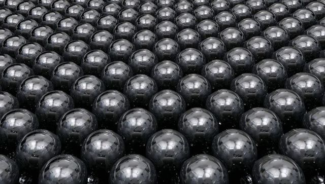 Glossy metallic spheres forming hexagonal reflective array with symmetry and depth
