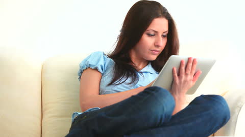 Young Woman Relaxing with Tablet on Comfortable Couch