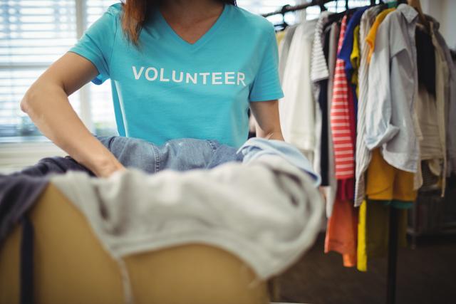 Female Volunteer Sorting Clothes for Donation - Download Free Stock Photos Pikwizard.com