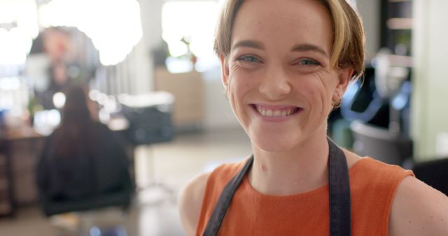 Smiling Young Hairdresser in Salon Wearing Apron - Download Free Stock Images Pikwizard.com