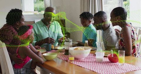 Multigenerational family gathering around dining table with green ar overlay