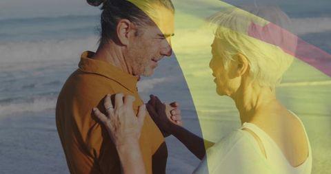 Gray-Haired Couple Embracing on Beach at Shoreline with Umbrella Light Leak Romance