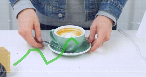 Hands placing green cup and saucer with latte art and rising trend graph overlay