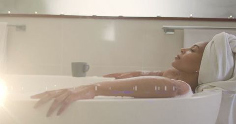 Woman Relaxing in Bathtub with Towel on Head