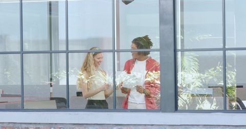 Colleagues Brainstorming in Modern Office Through Window