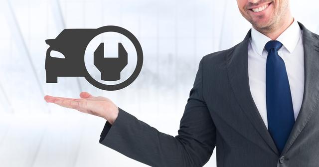 Businessman in suit and tie standing in modern office environment holding an icon representing car maintenance on his palm. Suitable for automotive industry promotions, car service advertisements, and professional business settings related to car repairs and technology improvements.