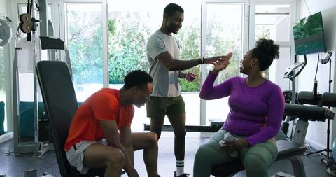 Friends Supporting Each Other While Working Out in Home Gym