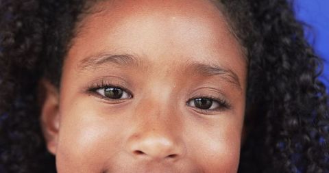 Close-Up of Biracial Girl with Curly Hair and Subtle Smile