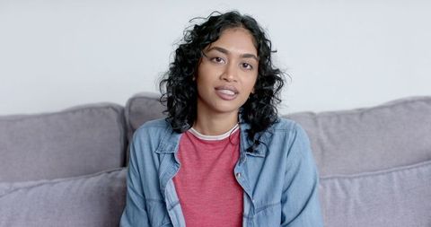 Relaxed young asian woman enjoying comfortable home video call