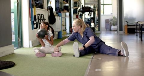 Therapist Assisting Girl with Cerebral Palsy in Rehabilitation Session