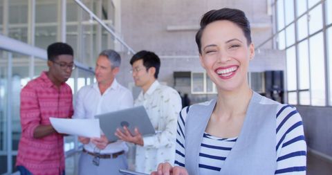 Confident Businesswoman Smiling while Team Collaborating in Background - Download Free Stock Images Pikwizard.com