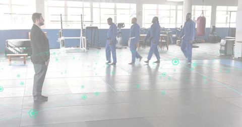 Martial Artists Walking Across Dojo Mats with Suit Observer Overseeing Training