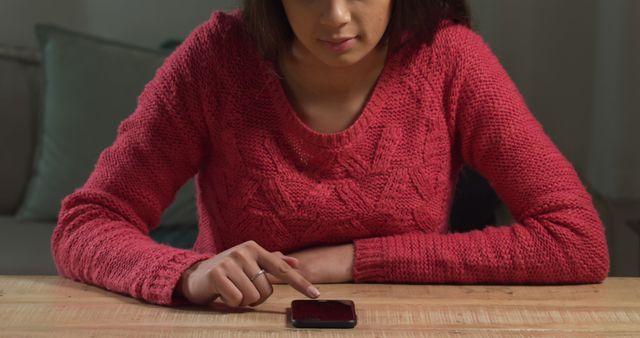 Young Woman Using Smartphone at Wooden Table in Dimly Lit Room - Download Free Stock Images Pikwizard.com