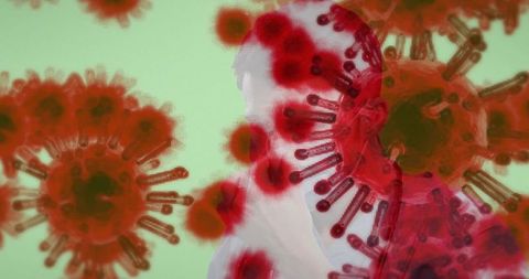 Masked man wearing surgical mask overlaid with red coronavirus particles on pale green background