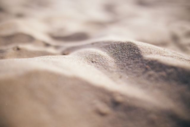 This image showcases a close-up view of sand dunes with soft focus, highlighting the textures and patterns of the sand. Ideal for backgrounds, website headers, environmental themes, relaxation concepts, and nature-inspired designs.