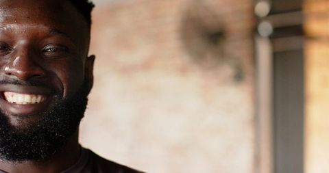 Smiling Man Against Industrial Brick Wall Background