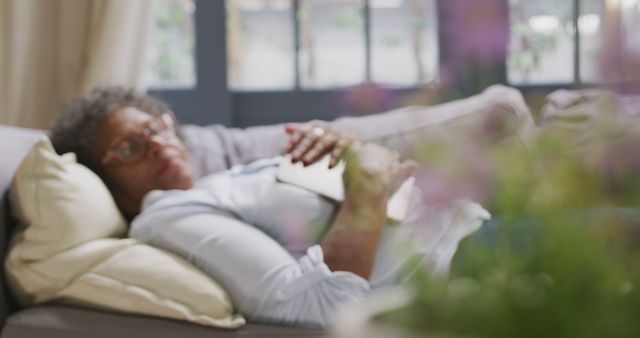 Senior Woman Relaxing on Sofa at Home with Book - Download Free Stock Images Pikwizard.com