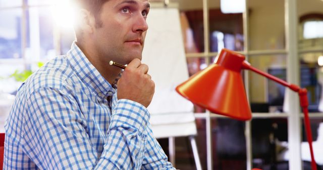 Businessman Pondering Ideas in Office with Pen in Hand - Download Free Stock Images Pikwizard.com