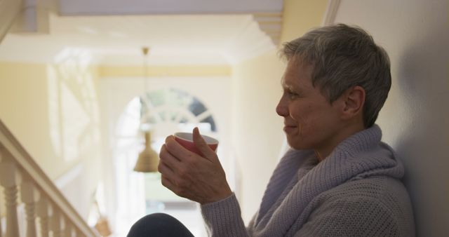 Older Woman Sipping Tea on Staircase in Cozy Home - Download Free Stock Images Pikwizard.com