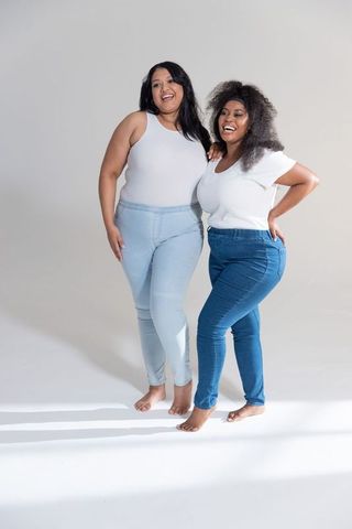 Plus size women modeling casual denim and white tops barefoot studio lifestyle