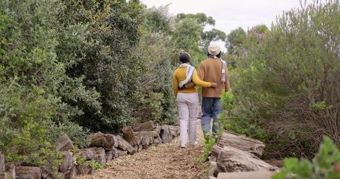 African american couple walking woodchip trail in coastal woodland embracing cozy stroll
