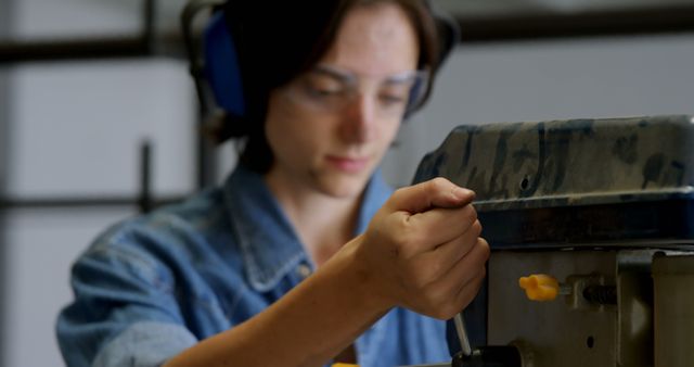 Young Woman Working with Machinery in Workshop - Download Free Stock Images Pikwizard.com