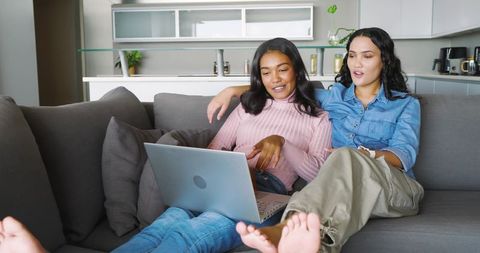 Cozy LGBTQ Couple Relaxing at Home with Laptop