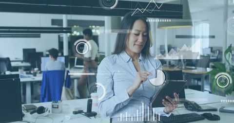 Businesswoman using tablet with digital financial interface overlays