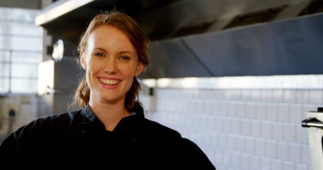 Female Chef Smiling in Commercial Kitchen with White Tiled Wall - Download Free Stock Images Pikwizard.com