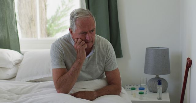 Elderly Man Sitting on Bed Contemplating in Bright Bedroom - Download Free Stock Images Pikwizard.com