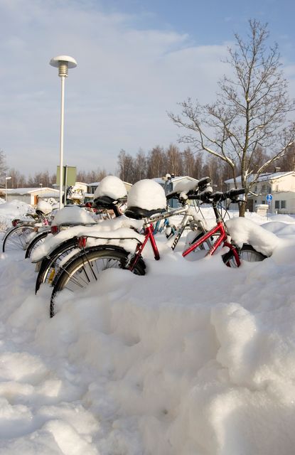 Bicycles buried under thick snow on a winter day. Perfect for articles or advertisements about winter weather, winter activities, climate change, outdoor biking challenges, or transportation issues during cold weather. Can also illustrate concepts related to outdoor sports and lifestyle in cold regions.