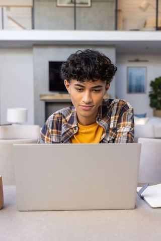 Casual Young Man Typing on Laptop in Modern Minimalist Living Room