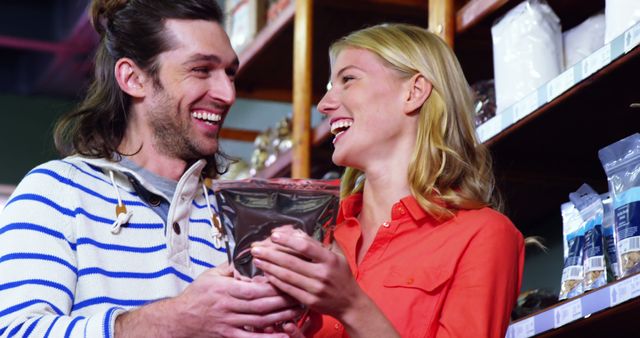 Image shows couple enjoying shopping together in grocery store, smiling and holding a bag of groceries. Ideal for retail promotions, advertisements for grocery stores, articles about shopping, or couple activities. Highlights themes of connection, happiness, and everyday life.