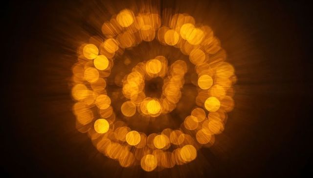 Glowing concentric bokeh rings radiating amber halo and radial light streaks