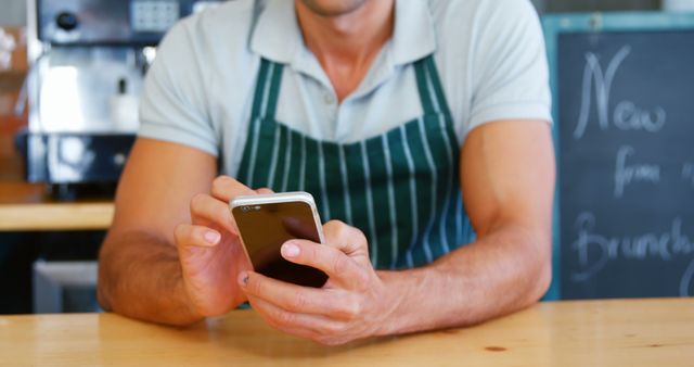 Cafe Barista Checking Phone During Break in Coffee Shop - Download Free Stock Images Pikwizard.com