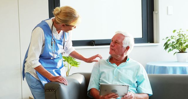 Nurse Conversing with Senior Patient Holding Tablet in Bright Room - Download Free Stock Images Pikwizard.com