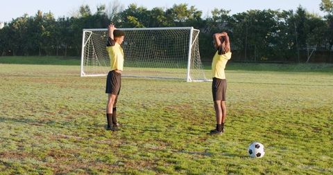 Soccer Teammates Stretching on Morning Field