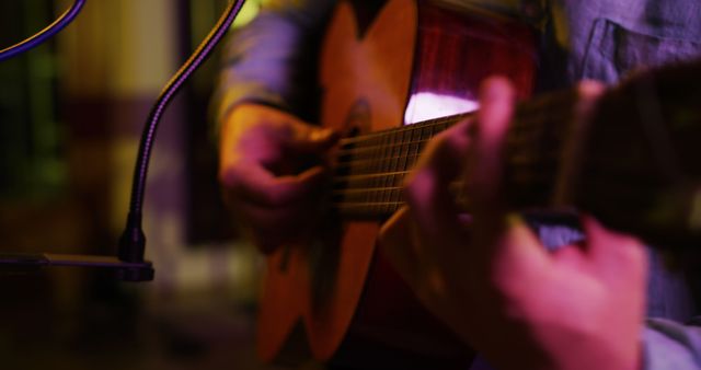 A male guitarist is playing an acoustic guitar in a studio recording session. - Download Free Stock Photos Pikwizard.com