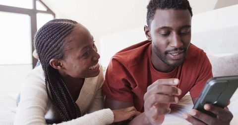 Couple Relaxing and Using Smartphone in Modern Bedroom