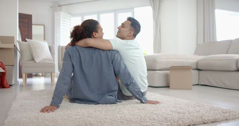 Happy Diverse Same-Sex Couple Relaxing in New Home Living Room