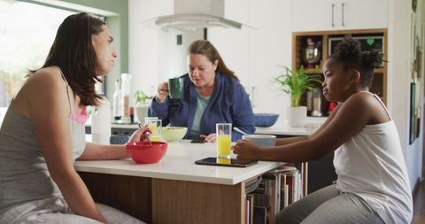 Diverse family sharing breakfast in kitchen together