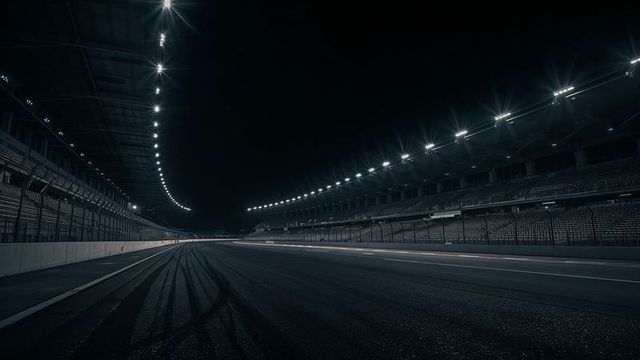 Illuminated Racing Track with Skid Marks Under Night Floodlights