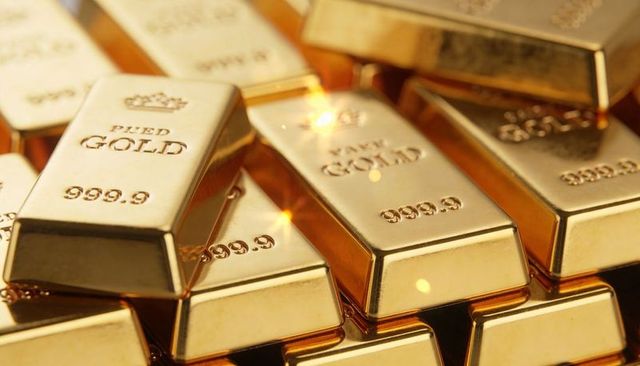Glinting stacked 999.9 fine gold bars reflecting warm light, luxury bullion close-up